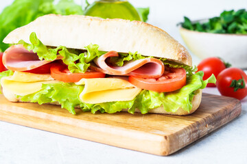Ciabatta sandwich with lettuce, cheese, tomatoes and ham.