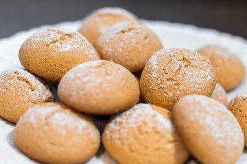 Close-up of homemade cookies dusted with powdered sugar on a white plate, sweet treat