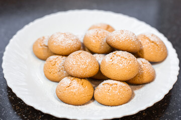 A plate of freshly baked cookies dusted with powdered sugar. A homemade dessert for tea