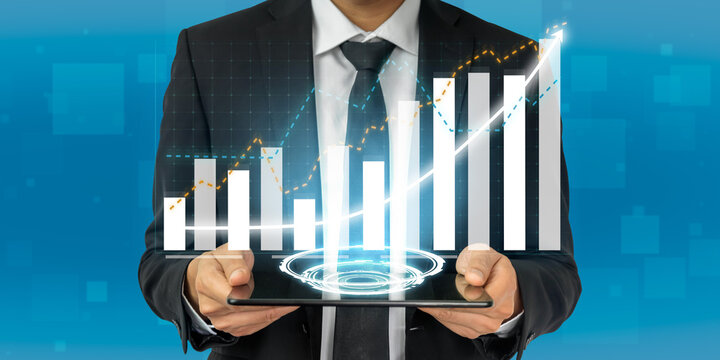 A businessman stands confidently while holding a tablet displaying a dynamic digital graph, symbolizing financial analysis, growth, and business innovation. Impute