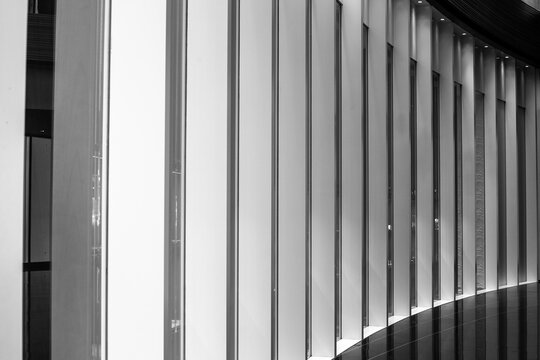 A minimalist black and white image of a curved wall with vertical slats creates a modern architectural accent