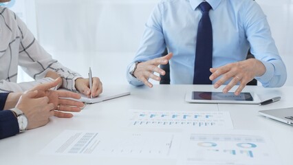 Business people reviewing financial metrics on digital screens, collaborating strategically while examining charts and graphs in office