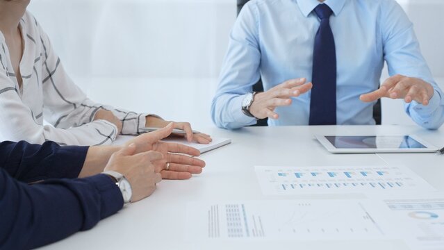 Business people reviewing financial metrics on digital screens, collaborating strategically while examining charts and graphs in office
