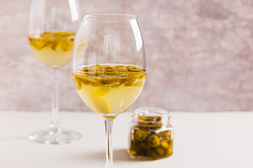 Chili white wine with jalapeno pieces in glasses close up