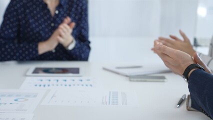 Business team applauding after successful presentation during a meeting in the office, celebrating achievement and good teamwork with positive attitude
