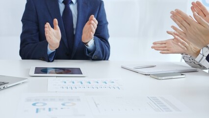 Professional business team clapping hands, celebrating successful presentation, showcasing collaborative spirit and corporate achievement in modern meeting space