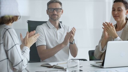 Professional team applauding, celebrating collaborative success and recognizing outstanding performance during corporate meeting, expressing shared workplace achievement. Business people concept