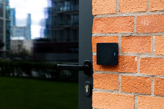 Access control system with card reader on brick wall, representing the integration of smart technologies in urban architecture. Step forward in modern construction for secure building management