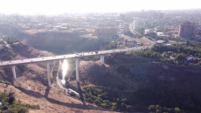 Drone view of a large bridge over a canyon connecting residential and industrial districts in Yerevan, Armenia.