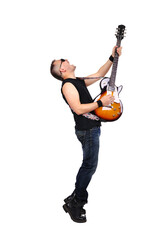 A male rock and roller expressively plays the guitar with it raised up.