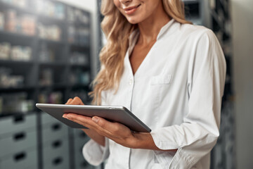 Pharmacist using digital tablet to manage inventory in pharmacy