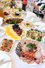 Festive table with meat dishes, vegetables, fruits and drinks.