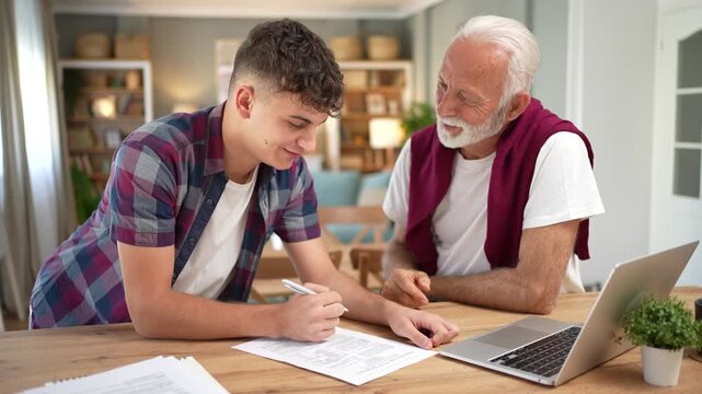 Grandson assisting his grandfather with paperwork at home