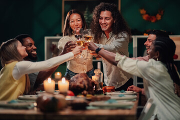 Friends toasting with wine at thanksgiving dinner table