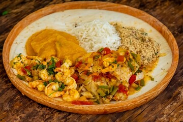 Brazilian moqueca capixaba is a typical dish from Espírito Santo, Brazil, with sea fish and shrimp, cooked in a clay pot and accompanied by white rice, pirão and farofa.