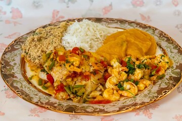 Brazilian moqueca capixaba is a typical dish from Espírito Santo, Brazil, with sea fish and shrimp, cooked in a clay pot and accompanied by white rice, pirão and farofa.
