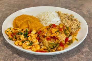 Brazilian moqueca capixaba is a typical dish from Espírito Santo, Brazil, with sea fish and shrimp, cooked in a clay pot and accompanied by white rice, pirão and farofa.