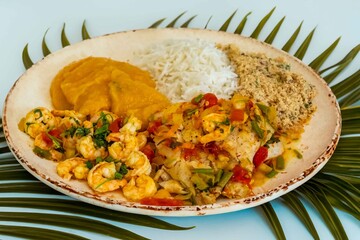 Brazilian moqueca capixaba is a typical dish from Espírito Santo, Brazil, with sea fish and shrimp, cooked in a clay pot and accompanied by white rice, pirão and farofa.
