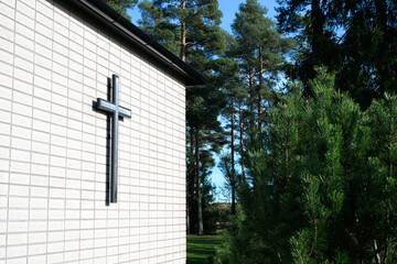 Cross on the wall of a church in the woods in Scandinavia. Christian concept