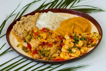 Brazilian moqueca capixaba is a typical dish from Espírito Santo, Brazil, with sea fish and shrimp, cooked in a clay pot and accompanied by white rice, pirão and farofa.