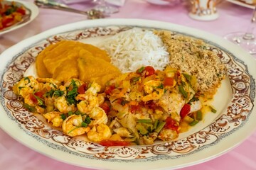 Brazilian moqueca capixaba is a typical dish from Espírito Santo, Brazil, with sea fish and shrimp, cooked in a clay pot and accompanied by white rice, pirão and farofa.