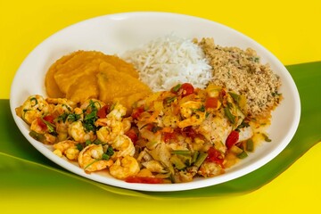 Brazilian moqueca capixaba is a typical dish from Espírito Santo, Brazil, with sea fish and shrimp, cooked in a clay pot and accompanied by white rice, pirão and farofa.