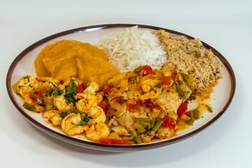 Brazilian moqueca capixaba is a typical dish from Espírito Santo, Brazil, with sea fish and shrimp, cooked in a clay pot and accompanied by white rice, pirão and farofa.