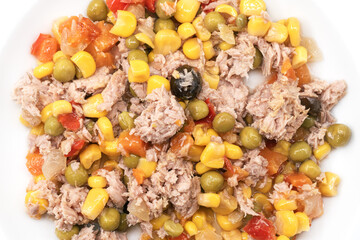 Close-up of tuna salad with corn, peas, carrots, and olives on a white plate. Healthy and colorful Mediterranean dish, perfect for balanced meals, light lunch, and nutritious recipes.