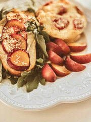 Toast with Camembert cheese, omelette, plum and arugula