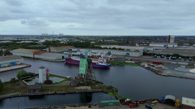 Aerial drone view of busy shipping port, industrial buildings and wharfs for loading and unloading cargo ships and tankers near Goole, United Kingdom