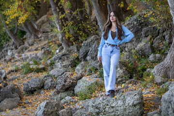 Naklejka premium Full body portrait of a young beautiful woman in blue jeans