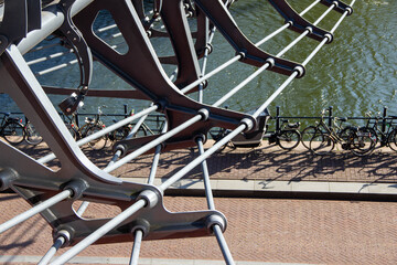 Modern architectural bridge structure with metallic cables and supports, overlooking a serene...