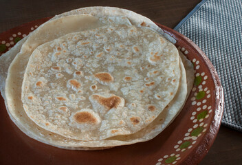 Flour tortillas on a handmade clay plate made in Mexico