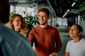 Happy business colleagues meeting and discussing work in a modern office environment, fostering teamwork and positive communication