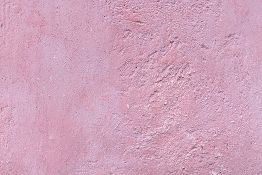  Detalle frontal de muro mexicano pintado de color rosa claro vibrante, textura. Concreto decorado con acabado rustico y cacarizo. Pared antigua tradicional con dise&ntilde;o de la epoca colonial.