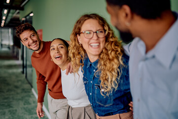 Diverse group of smiling business teammates showing unity, friendship, and positive work environment in a modern office