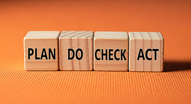 Plan do check act wooden blocks on orange background representing business strategy and improvement cycle