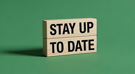 Wooden blocks displaying stay up to date message on a solid green background