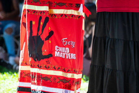 Sacramento, CA, U.S.A. - Sept. 2025: Close up of a skirt combining an Every Child Matter message with a Missing and Murdered handprint symbol on red at the California State Capitol public park.