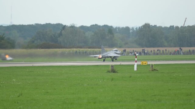JAS-39C Gripen takes off, jet stream soaring in clear countryside