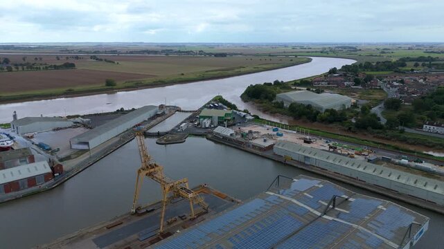 Aerial drone view of busy shipping port, industrial buildings and wharfs for loading and unloading cargo ships and tankers near Goole, United Kingdom