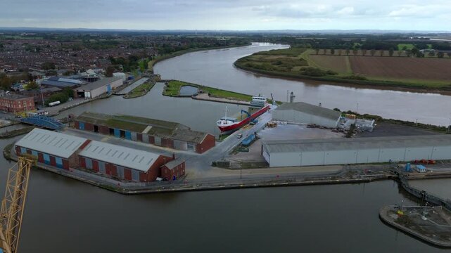 Aerial drone view of busy shipping port, industrial buildings and wharfs for loading and unloading cargo ships and tankers near Goole, United Kingdom