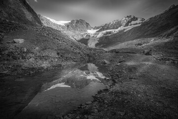 Black and white view of pond with mountains reflection on crystal clear waters. Vallelunga, Alto Adige, Italy
