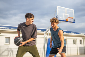 Young men playing basketball on outdoor court
