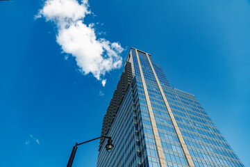 Modern skyscraper reflecting the vibrant blue sky. Perfect for corporate or architectural themes.
