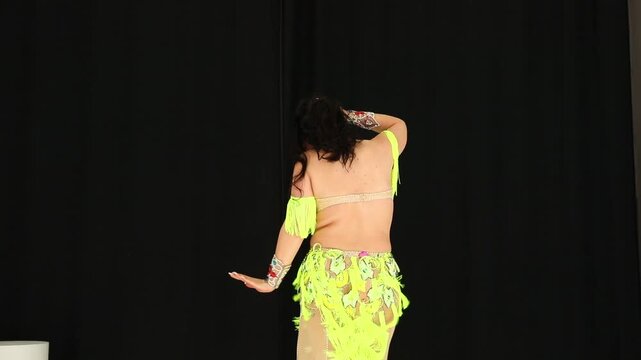 Sexy brunette woman in dance costume dancing in studio