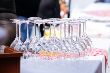 Elegant arrangement of clear wine glasses on a table with a checkered tablecloth, showcasing a refined dining setup for outdoor gatherings