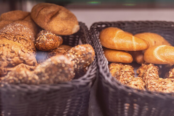 Freshly baked rolls and pastries in woven baskets at a local bakery during morning hours