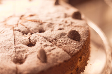 Delicious chocolate cake topped with powdered sugar and chocolate chips at a dessert shop during a cozy afternoon