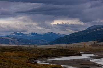 Dramatic mountain landscape with winding river under stormy skies - perfect for nature lovers and...